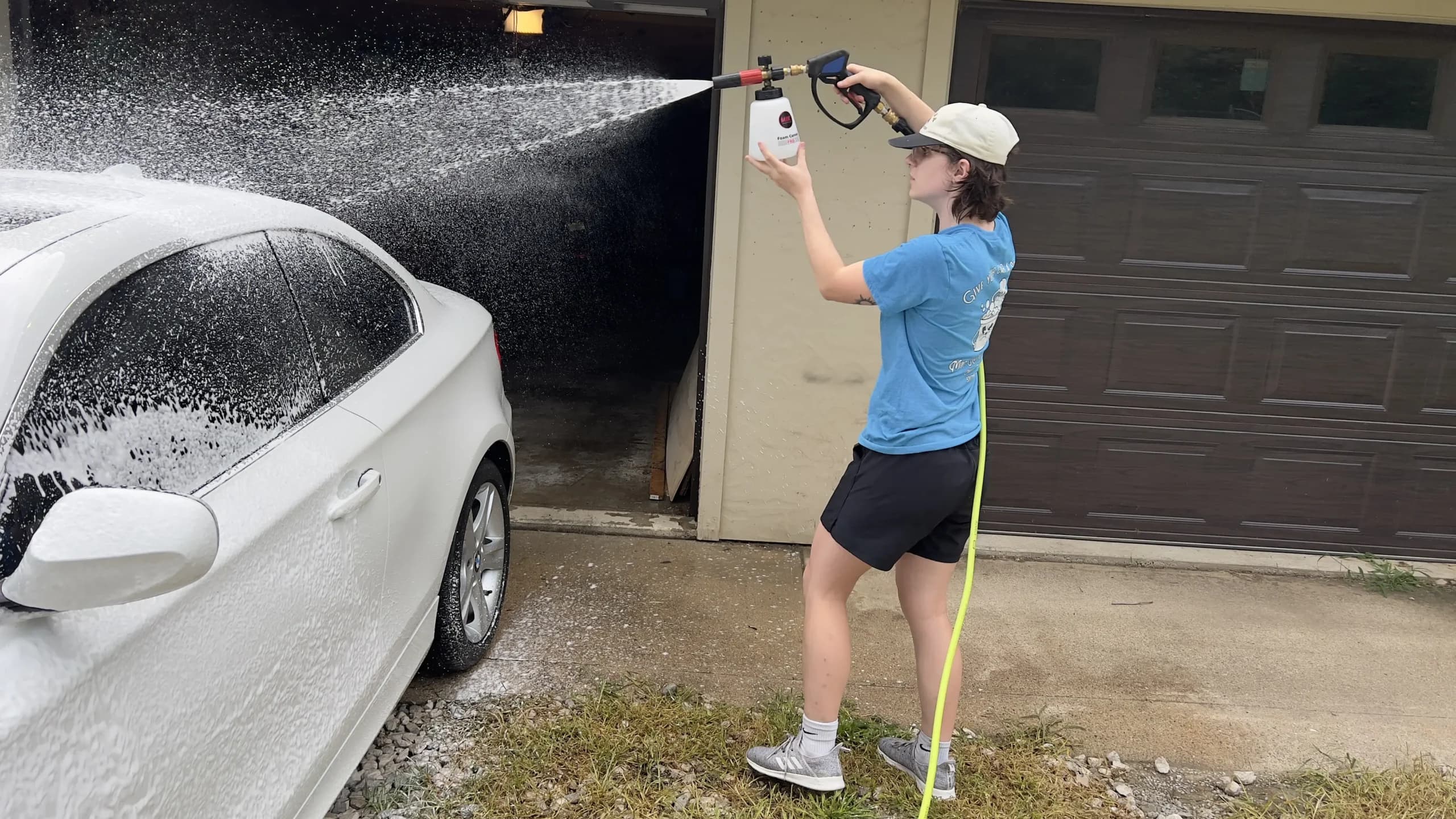 Maryam foam-washing a car in a driveway