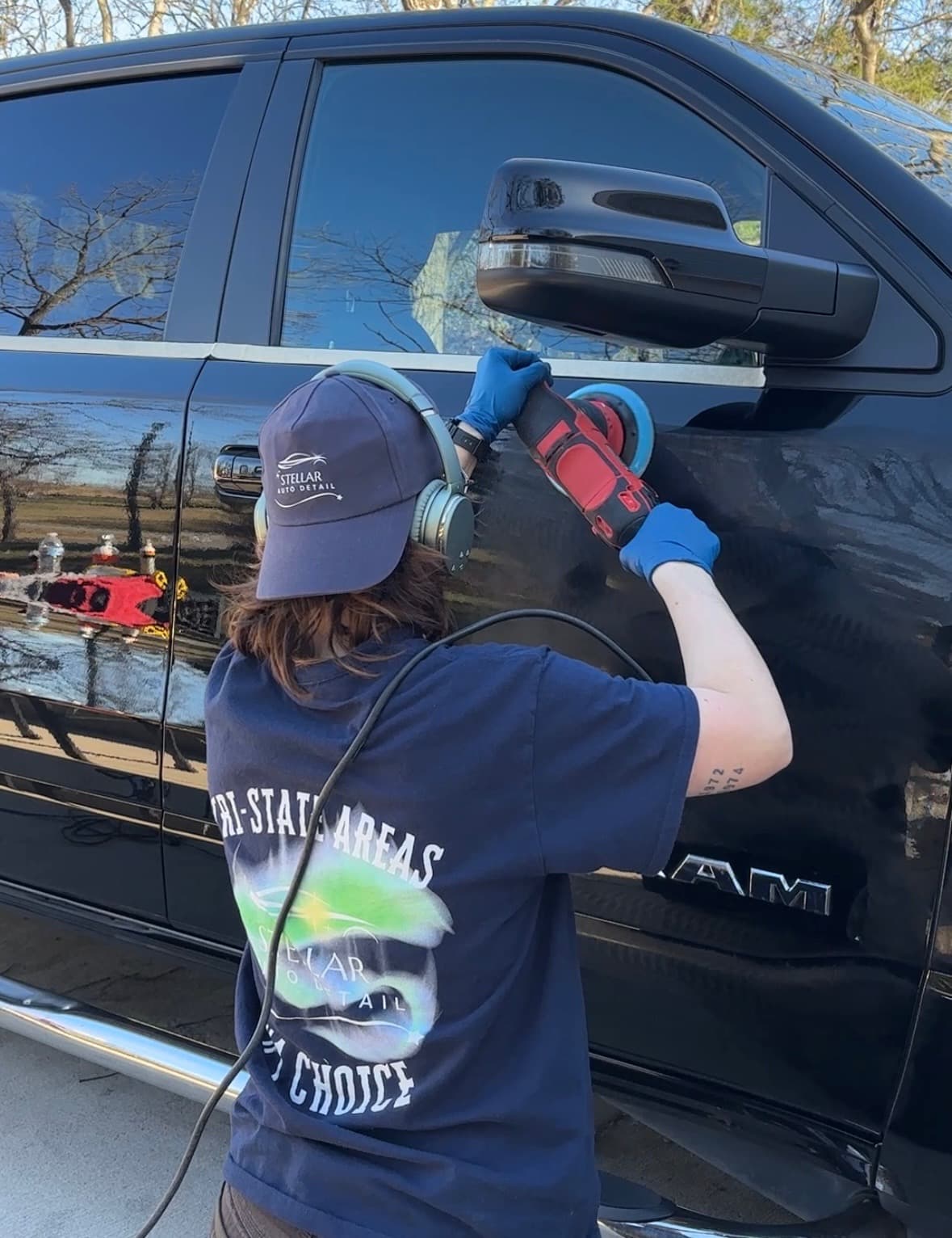 Maryam polishing a truck in her Stellar Auto Detail branded gear